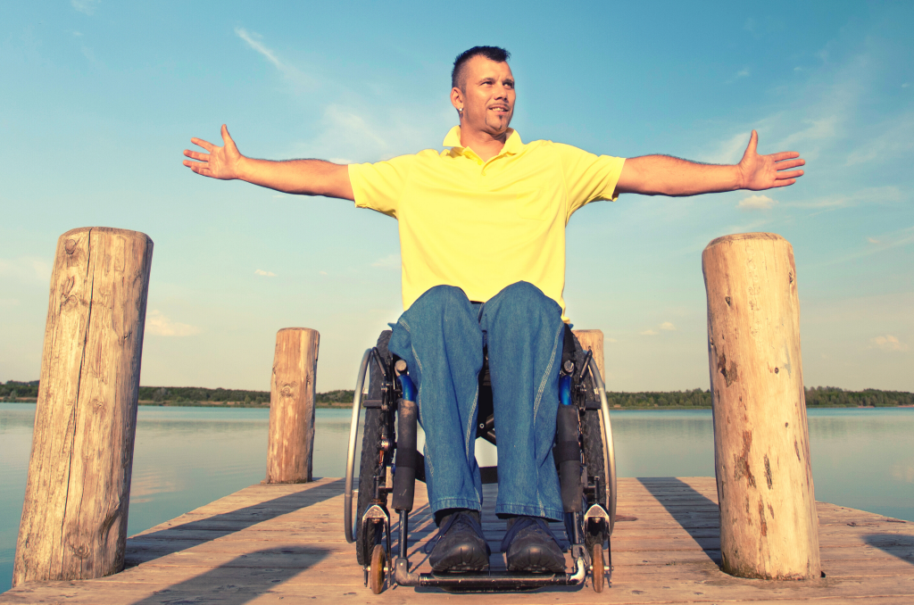 Persona con discapacidad en un muelle, disfrutando del verano.